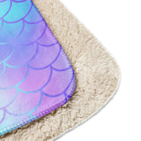 An image showing both sides of the blanket to highlight the smooth front and Sherpa reverse.