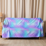 The blanket casually draped over a sofa or sectional to show how it looks and feels in a real living room setting.